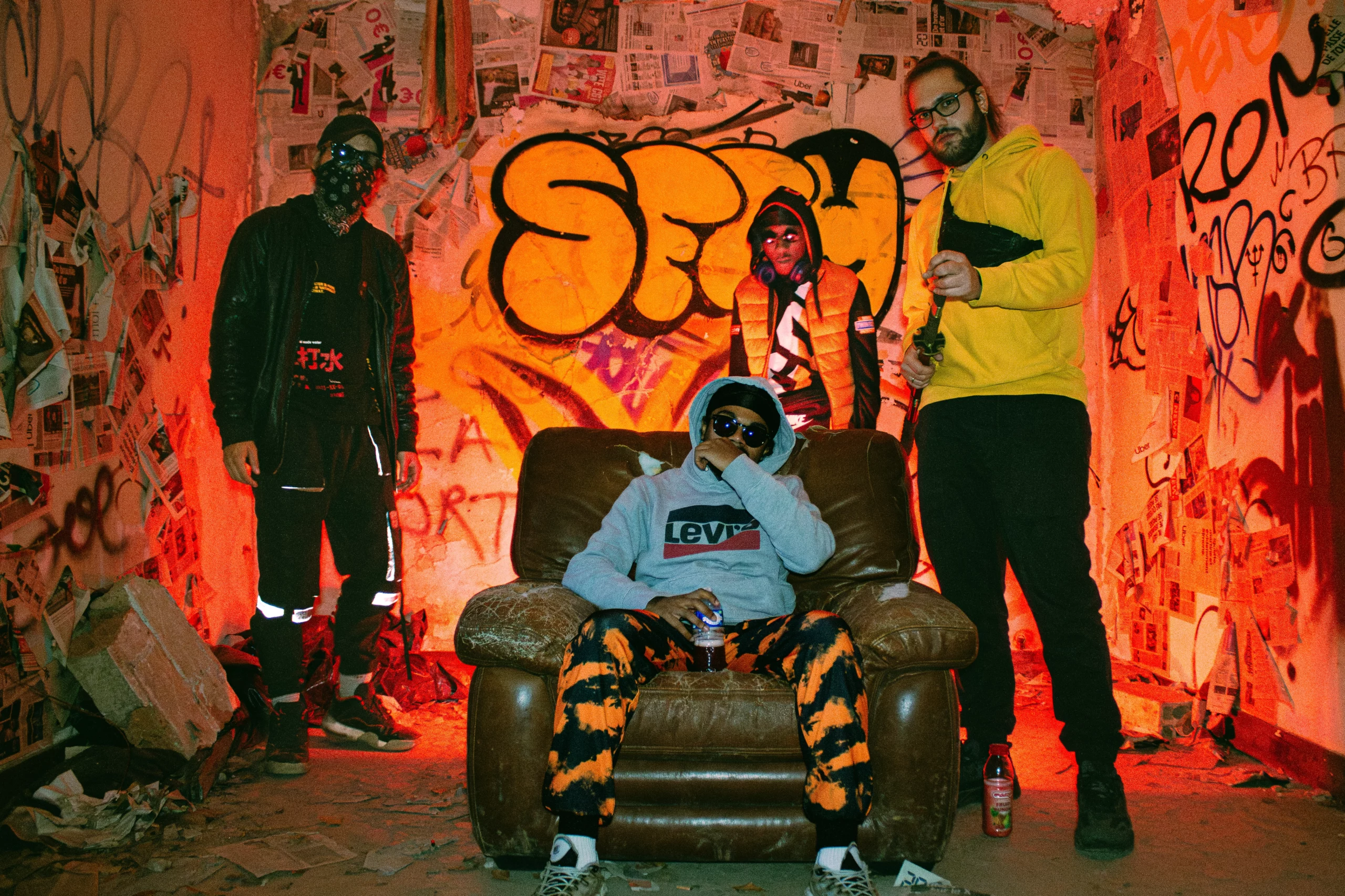 Groupe rap en décor graffiti, ambiance urbaine underground aux lumières rouges intenses.