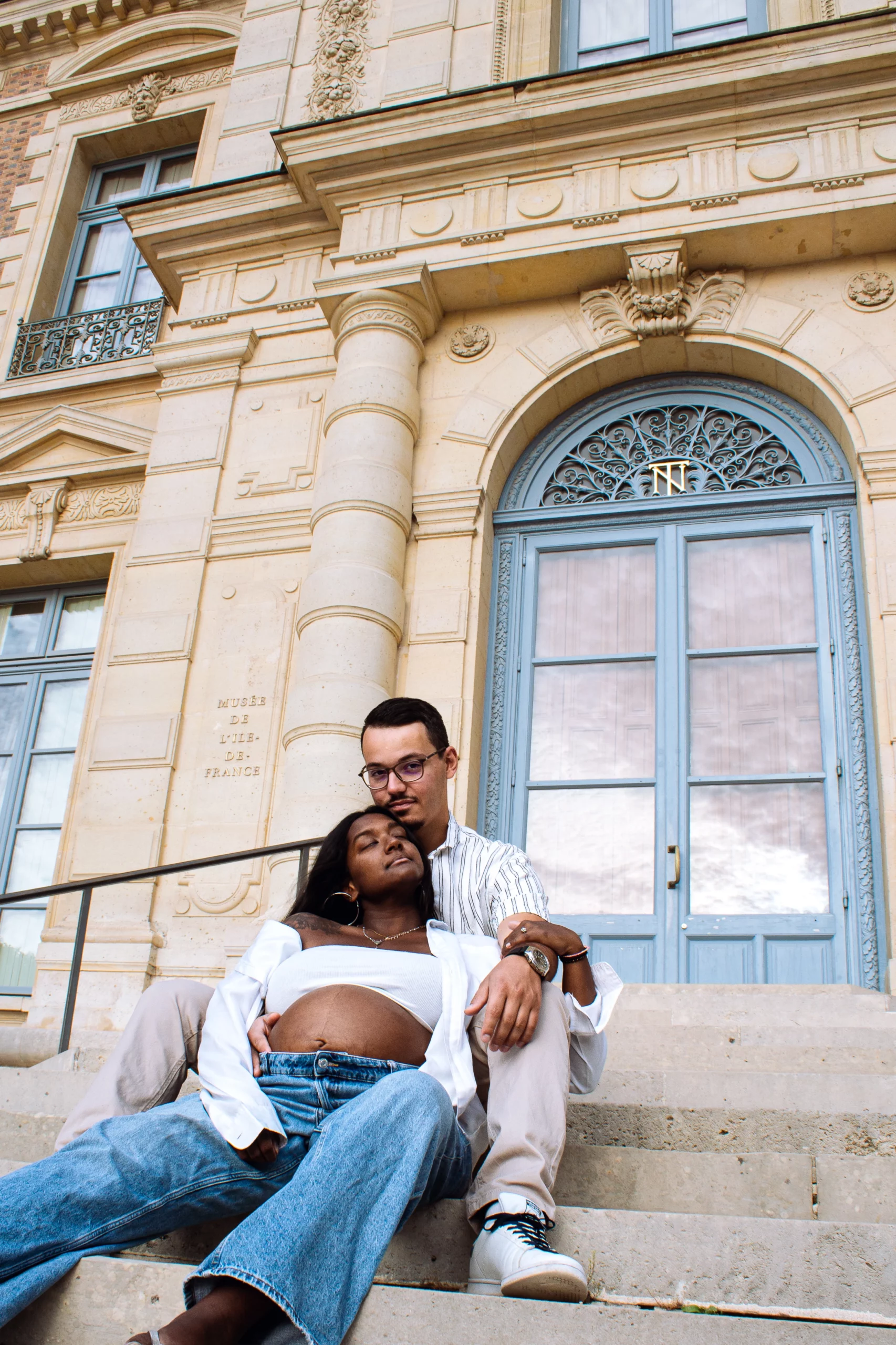Photographie d'un couple qui sont assis et enlacés sur des marches.