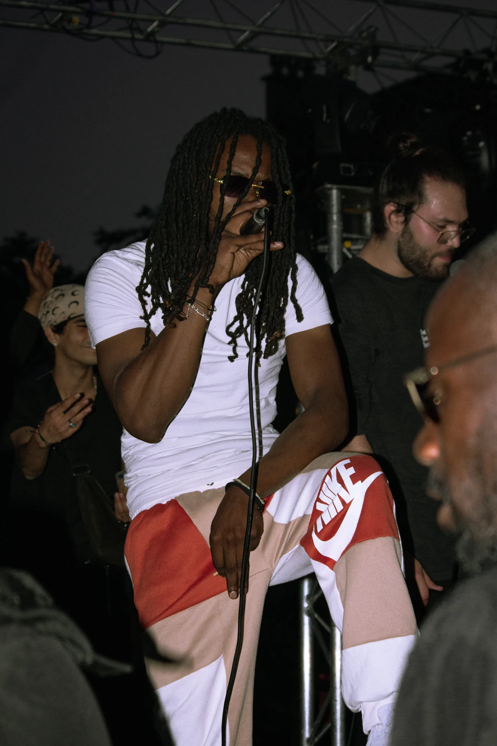 Photographie de concert rap capturant l’artiste en pleine performance live avec intensité.