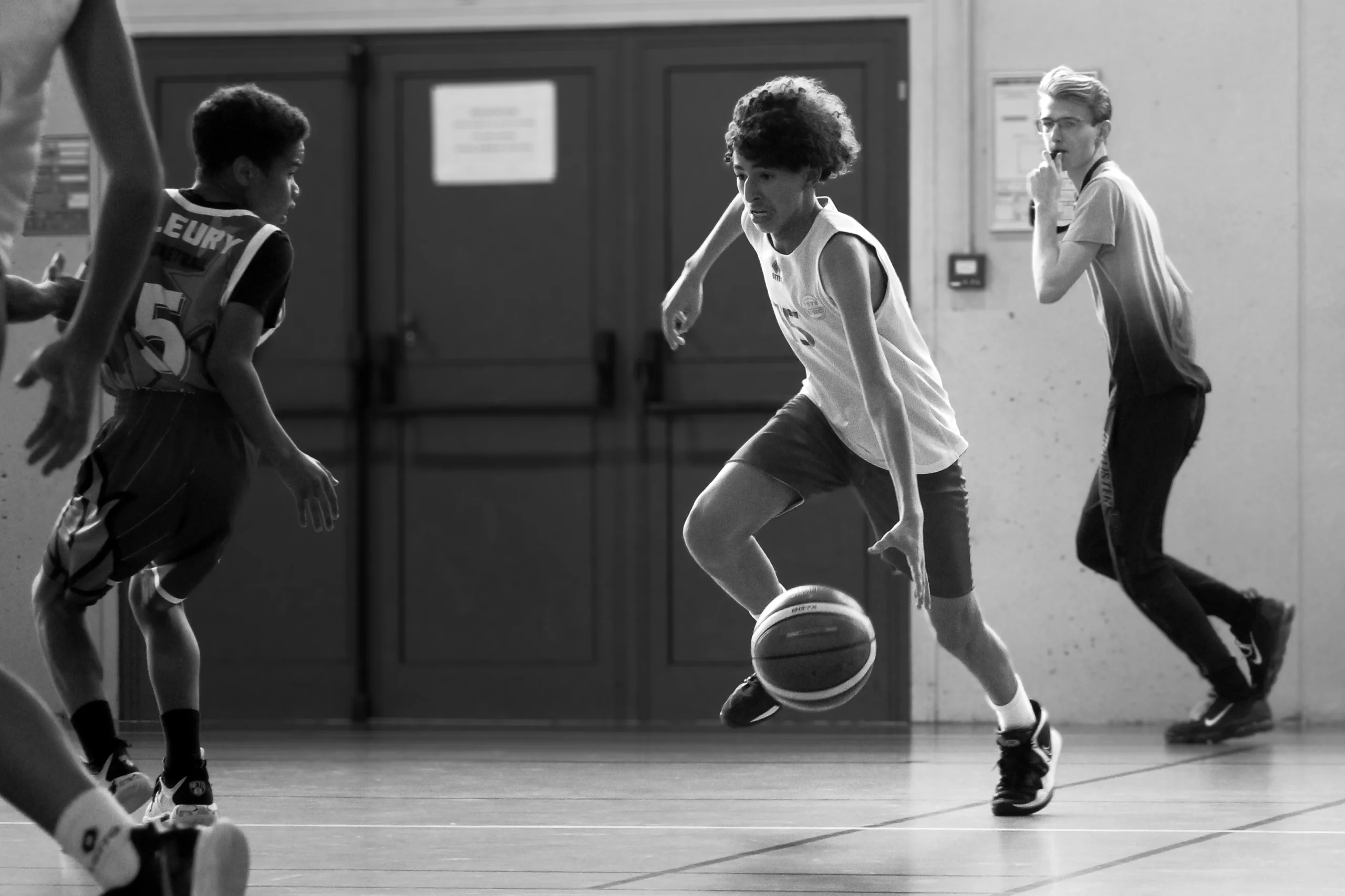 Photographie d'un basketteur qui traverse la défense.