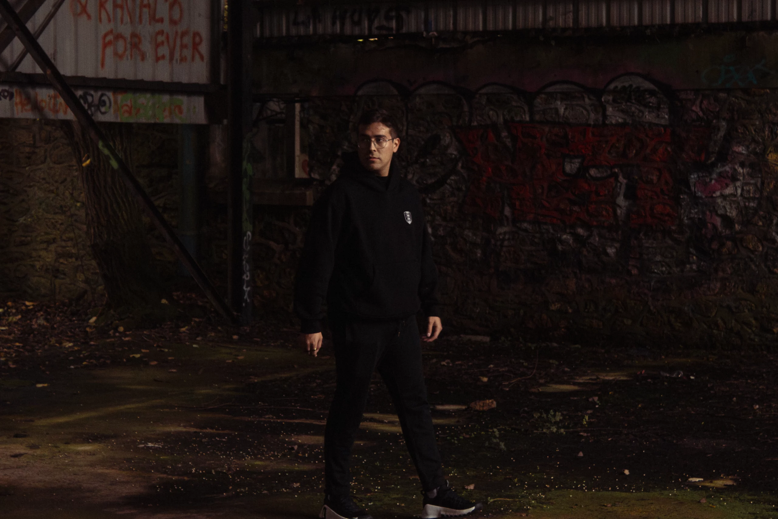 Photographie sombre d'un homme dans un lieu abandonné.
