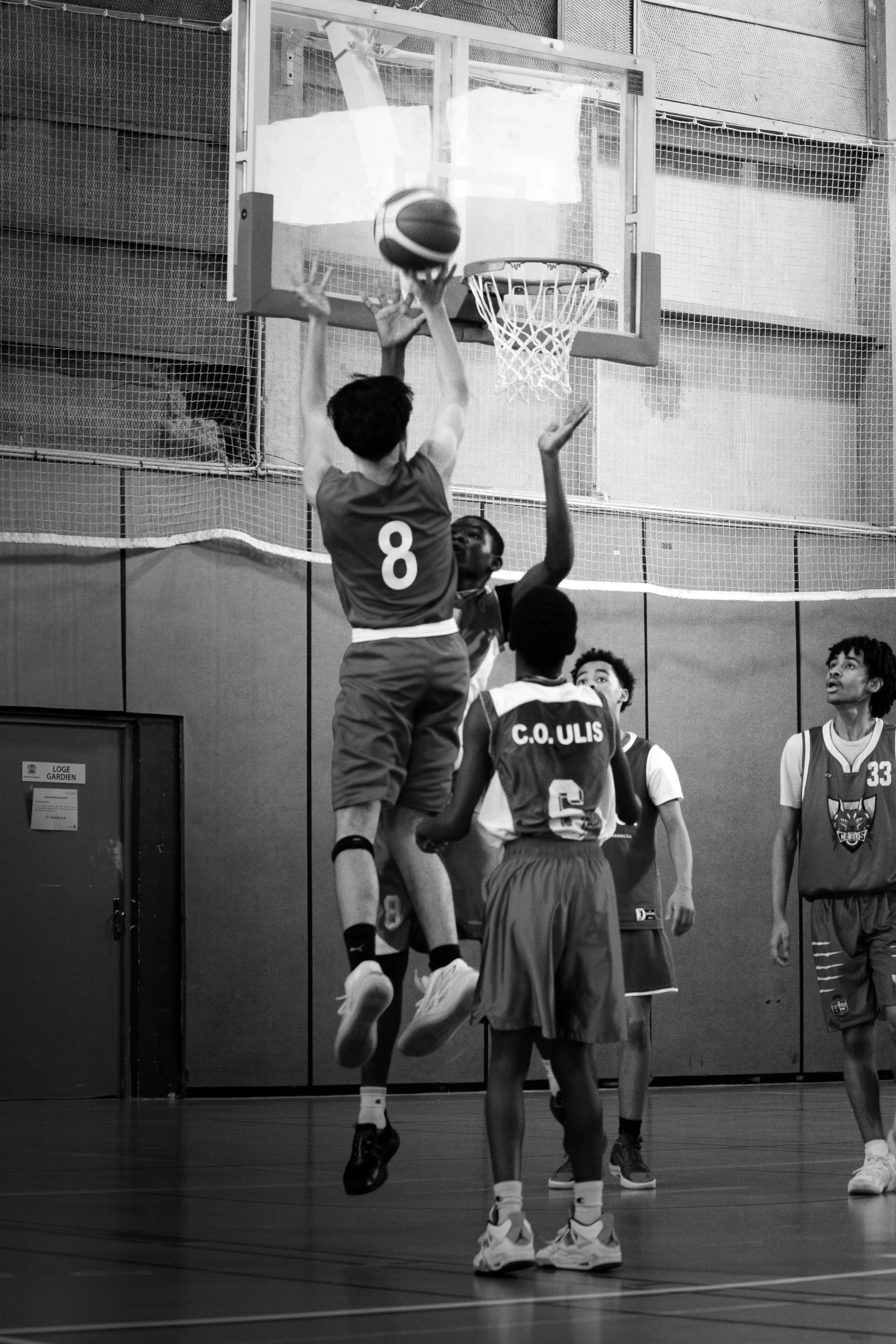 Photographie du saut d'un basketteur s'apprêtant à mettre un panier.